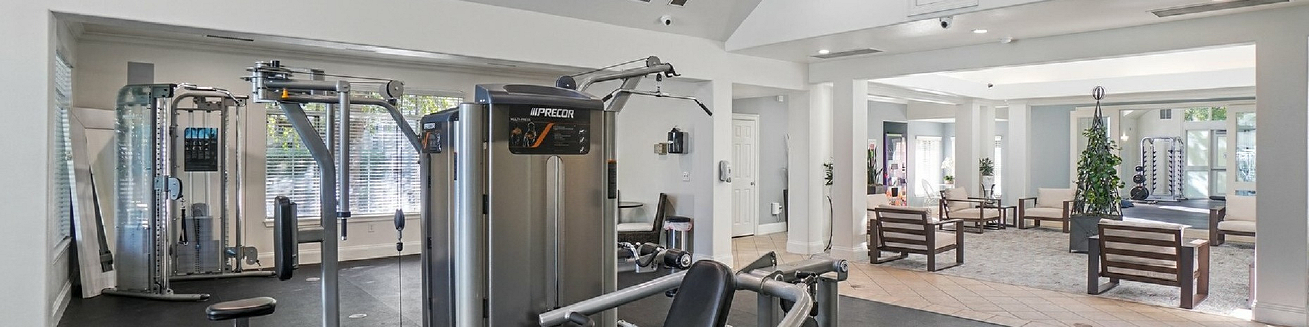 Modern fitness center with sleek gym equipment and a welcoming lounge area, designed for luxurious comfort and wellness.
