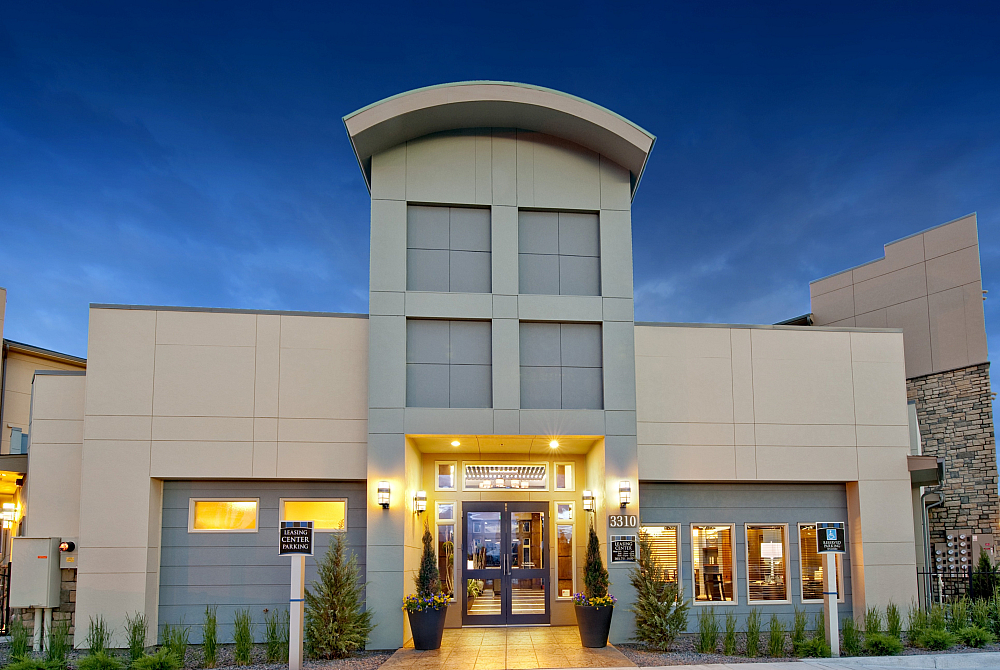 Modern and elegant apartment building exterior with a contemporary architectural design, featuring well-maintained landscaping and warm lighting, creating a welcoming atmosphere.