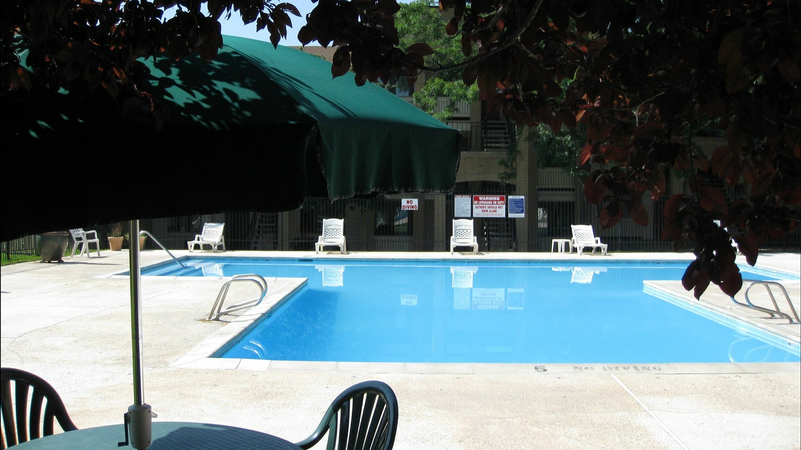 Inviting pool area with sun loungers and shaded seating, perfect for relaxation and leisure.