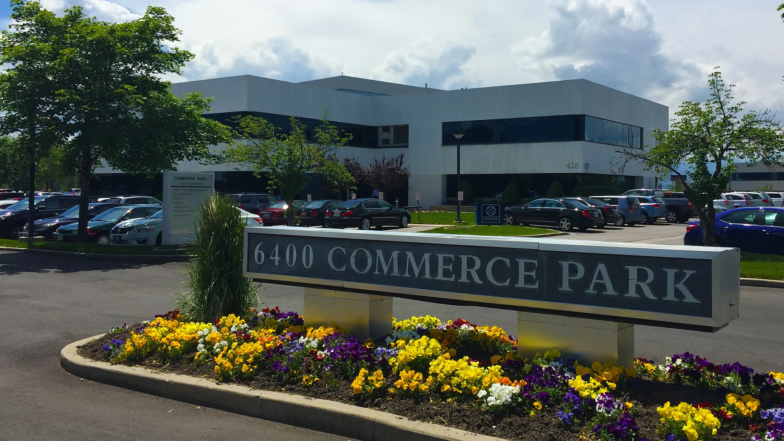 Bright and modern commercial building at 6400 Commerce Park, surrounded by vibrant flowers and ample parking.
