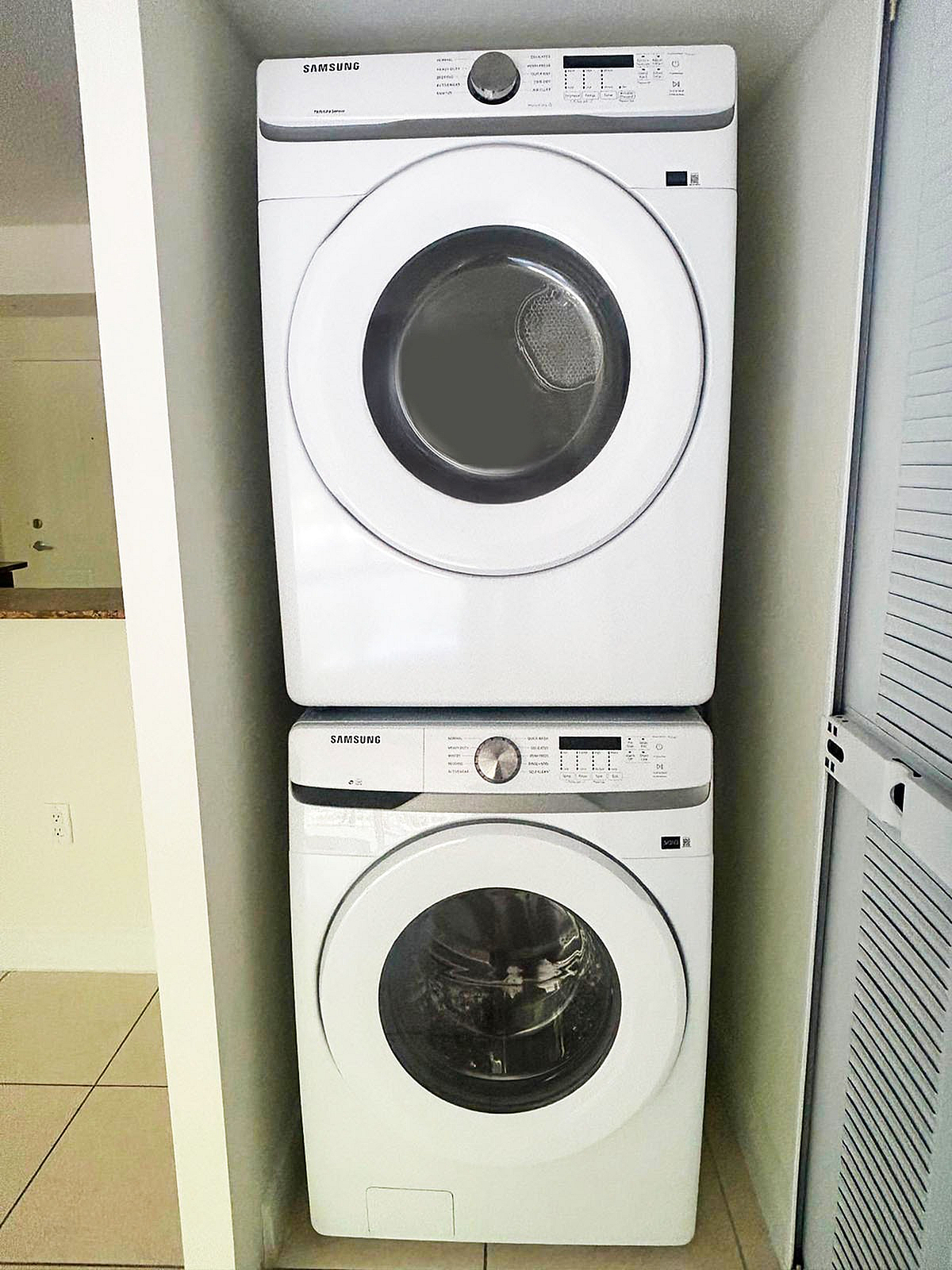 Modern apartment laundry area with stacked Samsung washer and dryer offering efficient use of space.