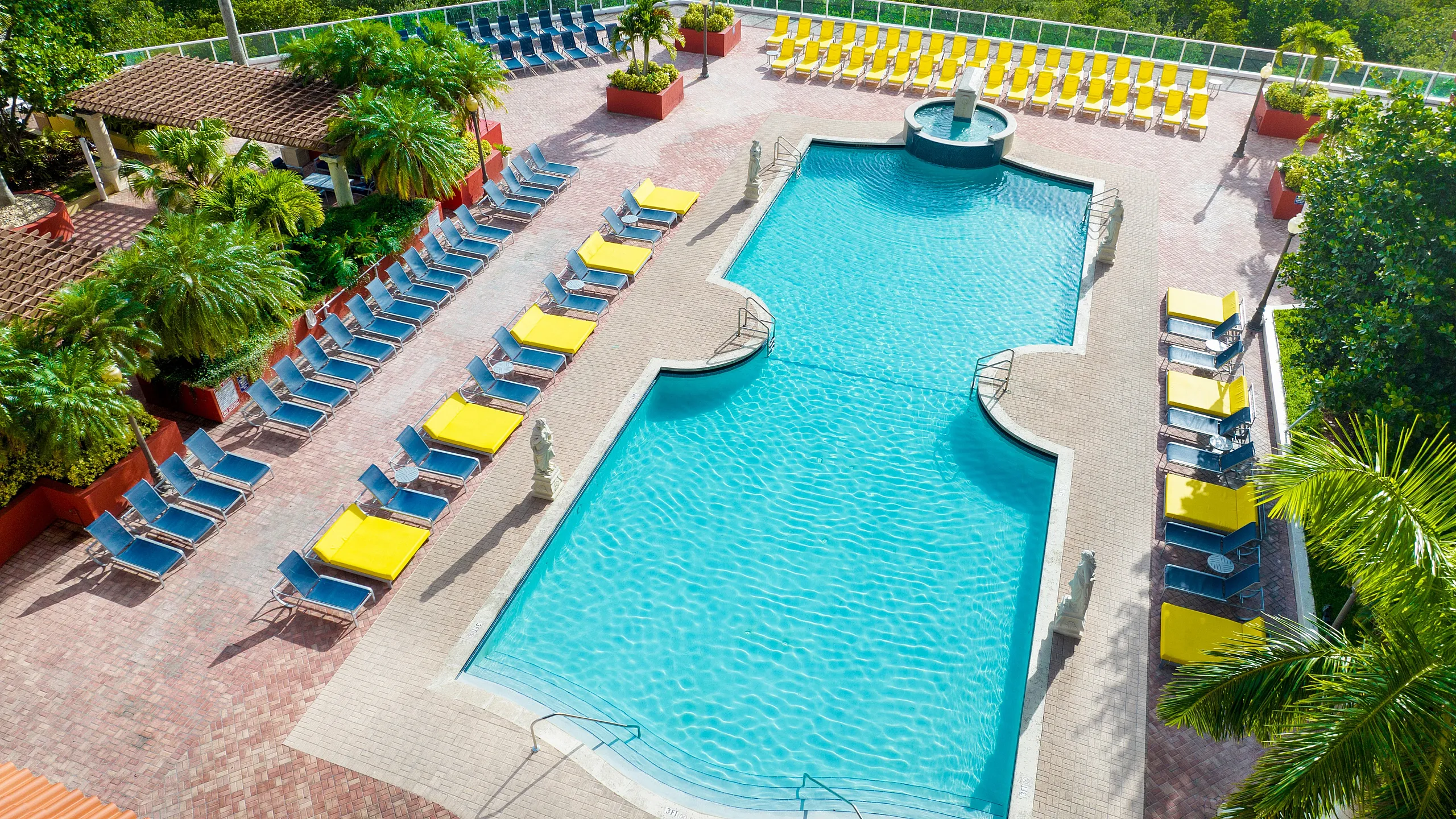 Luxurious outdoor pool area with inviting sun loungers and lush greenery, perfect for relaxation and leisure.