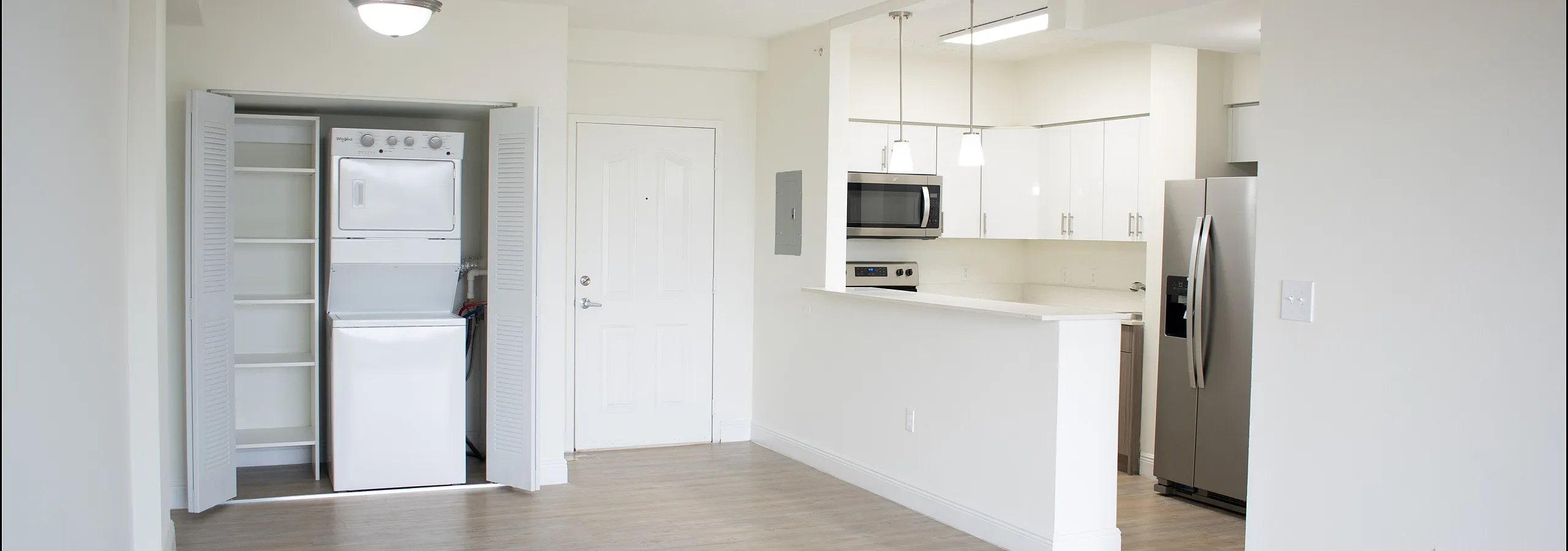 Bright, modern apartment with an open-concept design, featuring sleek kitchen appliances and in-unit laundry.