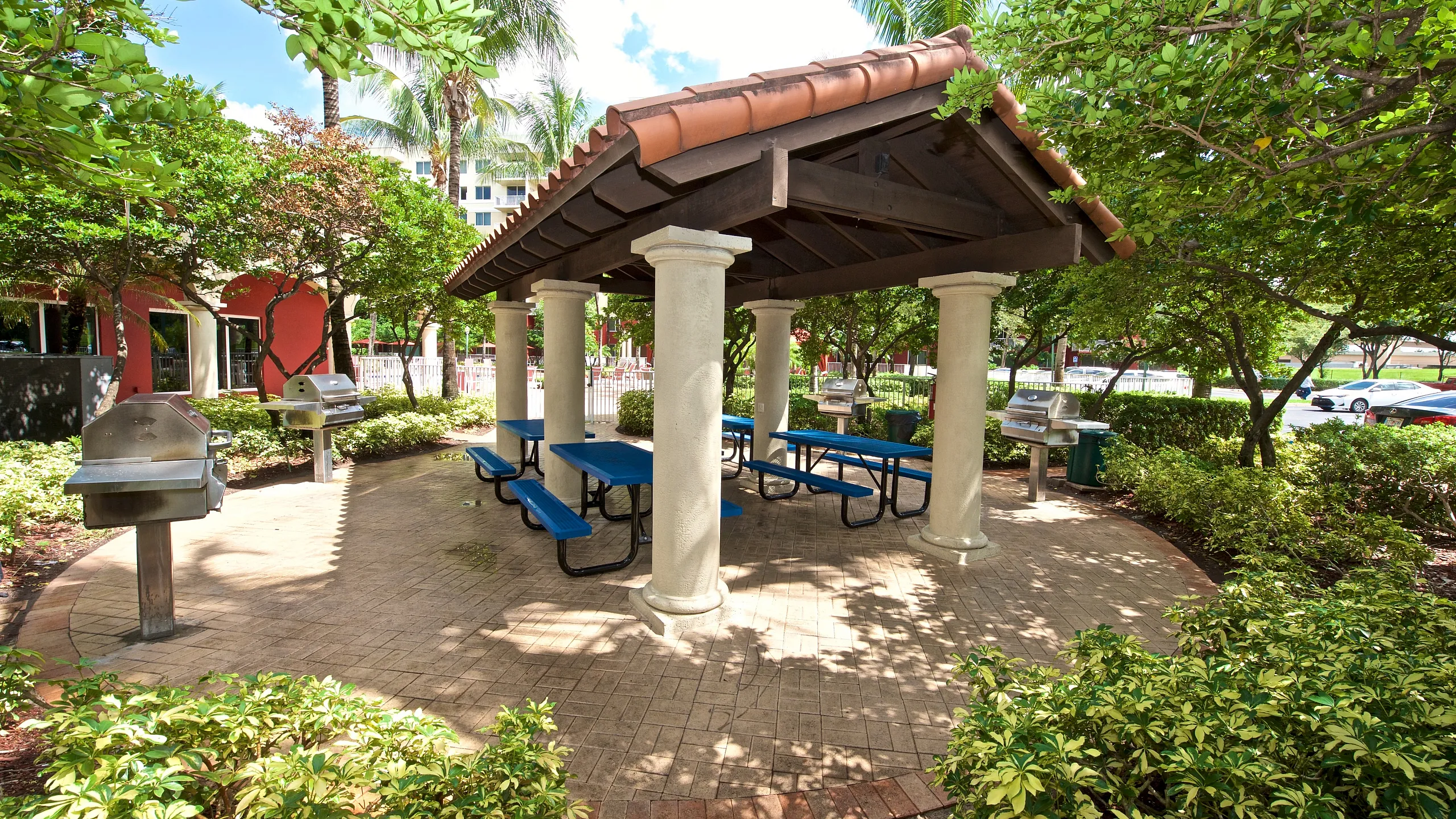 Charming outdoor picnic area with a covered pavilion, surrounded by lush greenery and equipped with grills for perfect weekend gatherings.