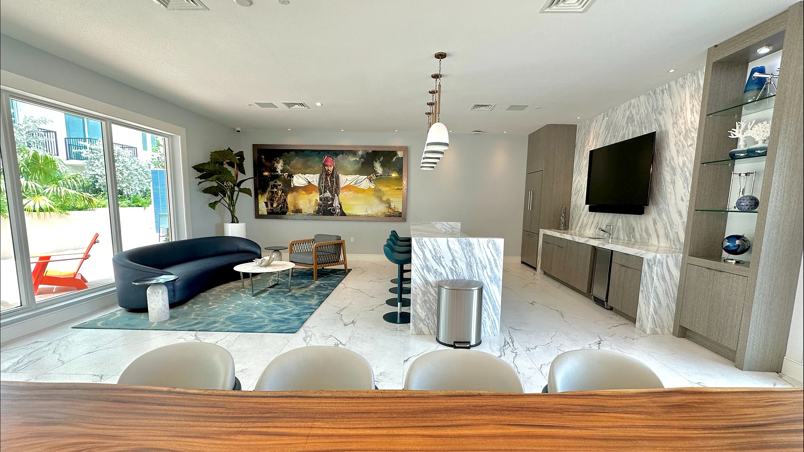 Luxurious and modern living space with stylish marble accents, a chic blue sofa, and floor-to-ceiling windows offering abundant natural light.