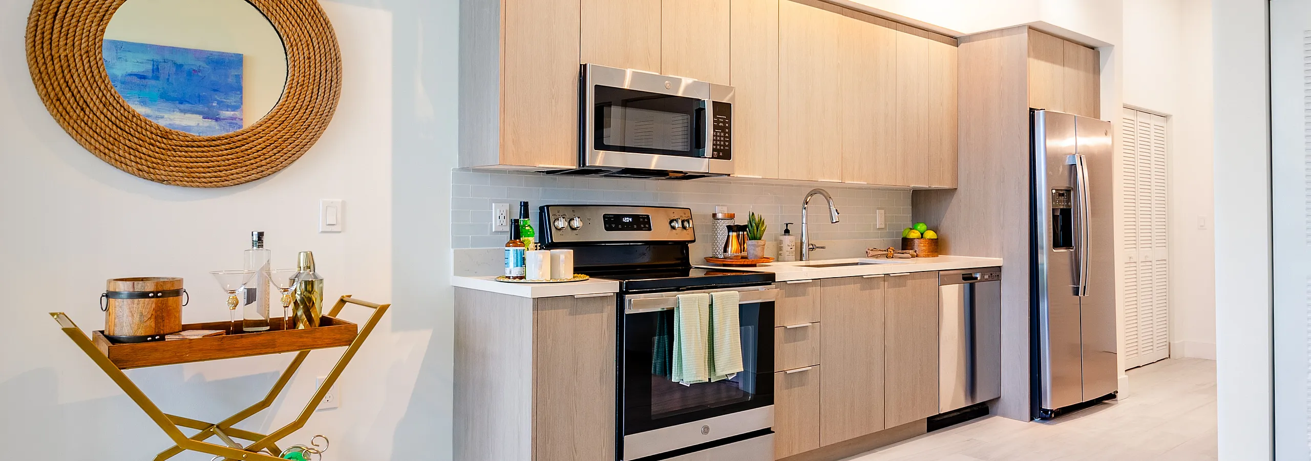 Modern kitchen with sleek stainless-steel appliances, elegant cabinetry, and a stylish bar cart in a bright, open space.