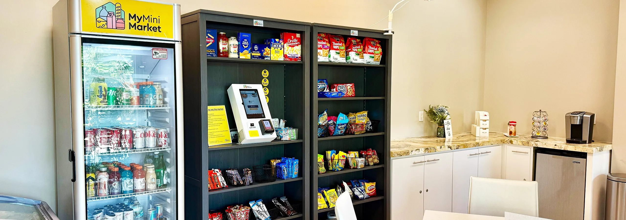 Chic mini-market corner with stocked shelves, a variety of snacks, and a refreshing drinks fridge in a modern setting.