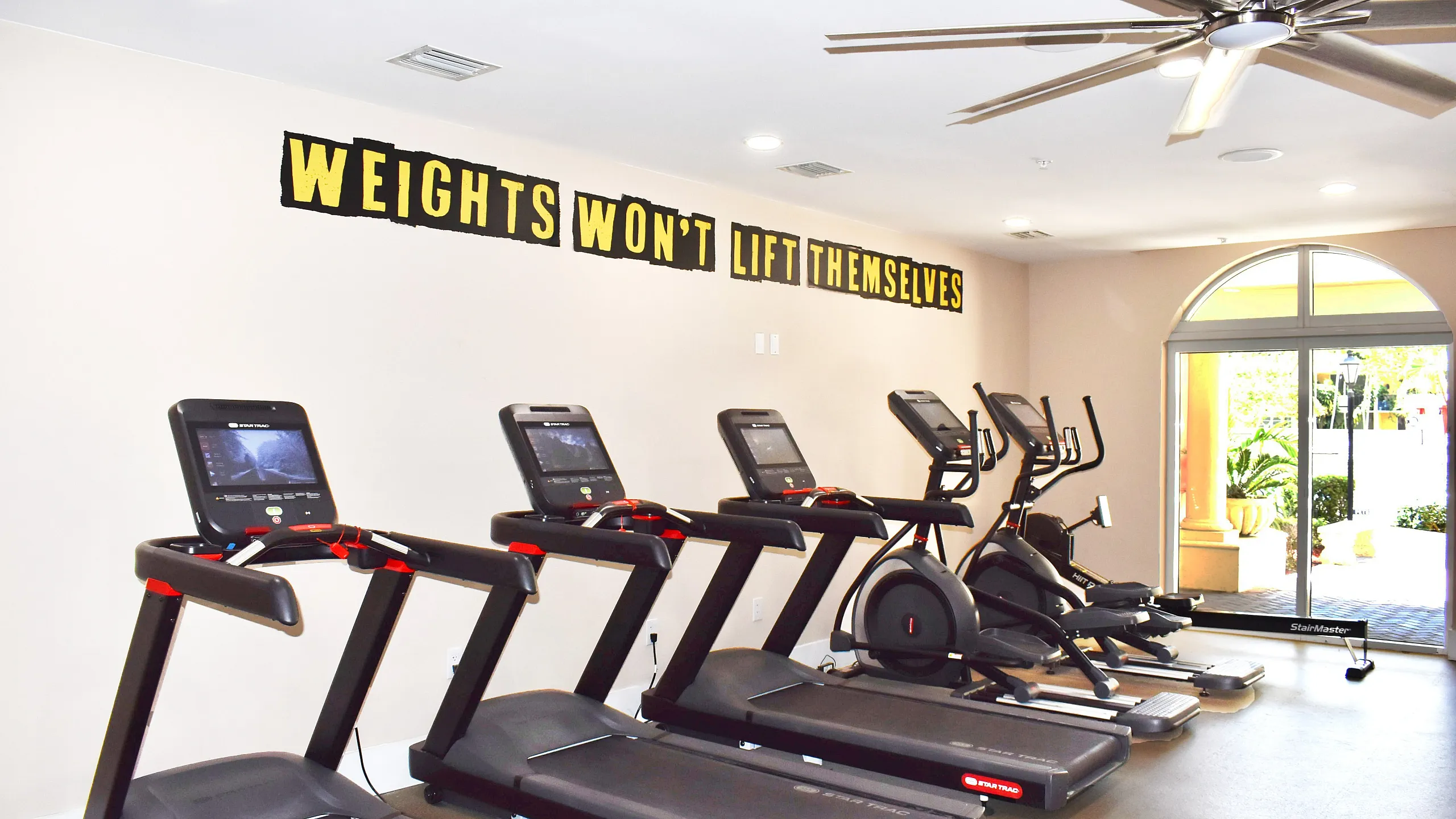 Inviting fitness center featuring modern treadmills and motivational wall art, perfect for energizing workouts.