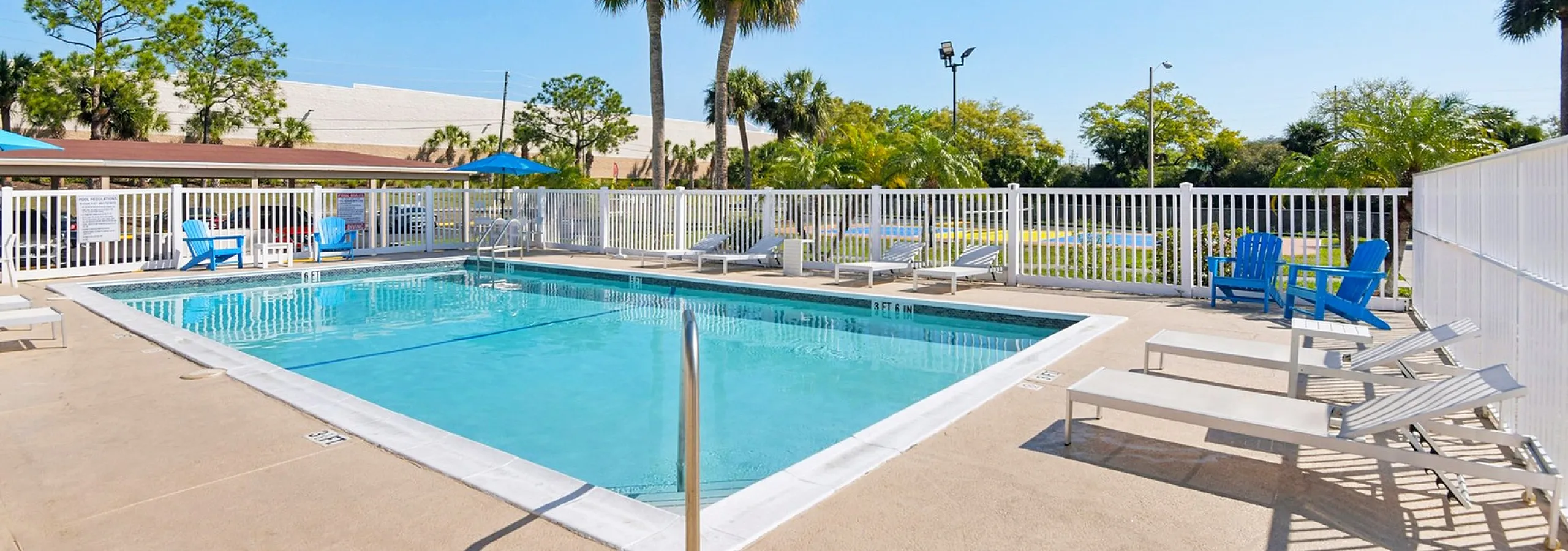 Inviting outdoor swimming pool surrounded by sun loungers and vibrant greenery, perfect for relaxation and leisure.