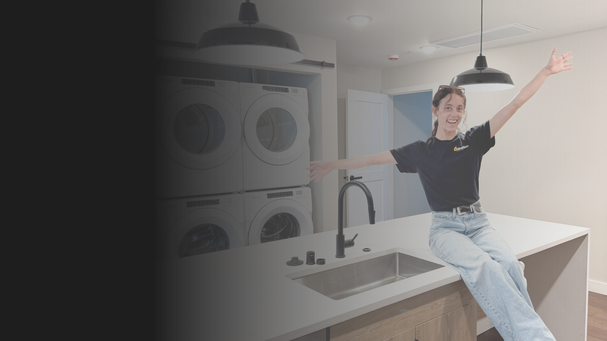 image of leasing manager sitting on the counter of the island in the apartment building with the washer/dryer in the background
