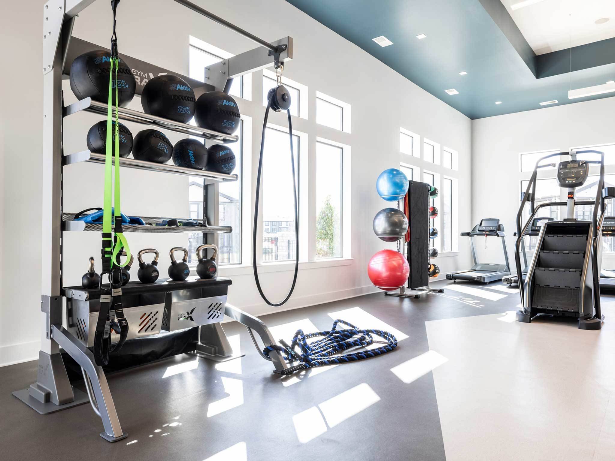 Interior and bright fitness center, TRX and Stairmaster