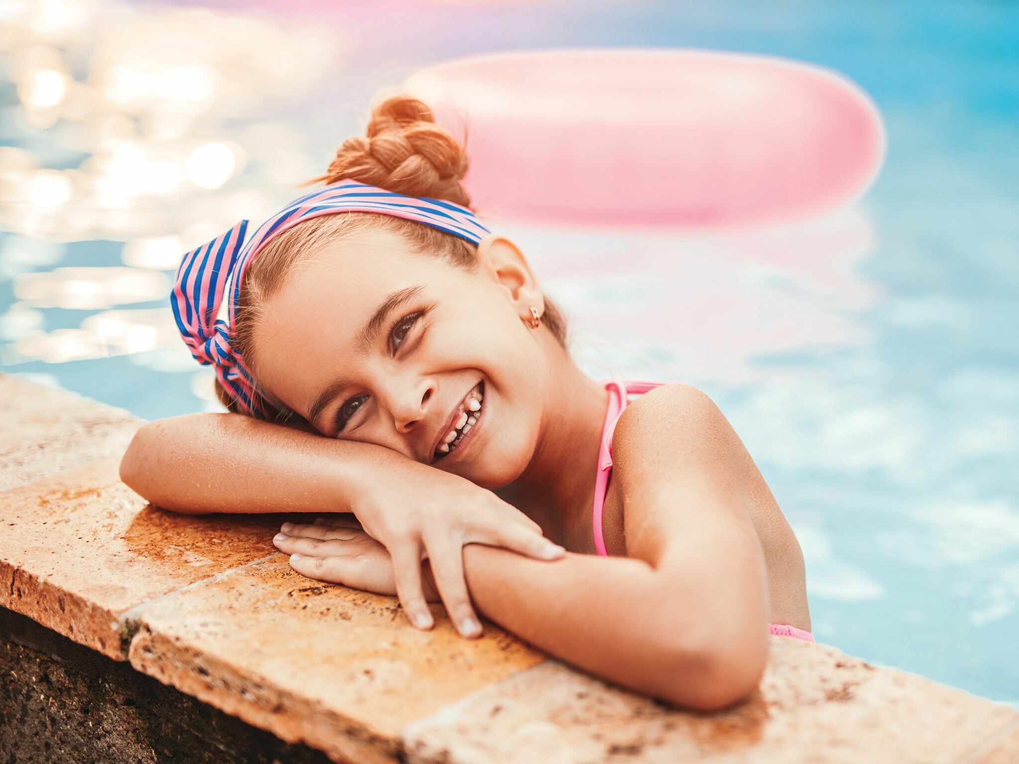 joyful little girl in swimming pool in aurora