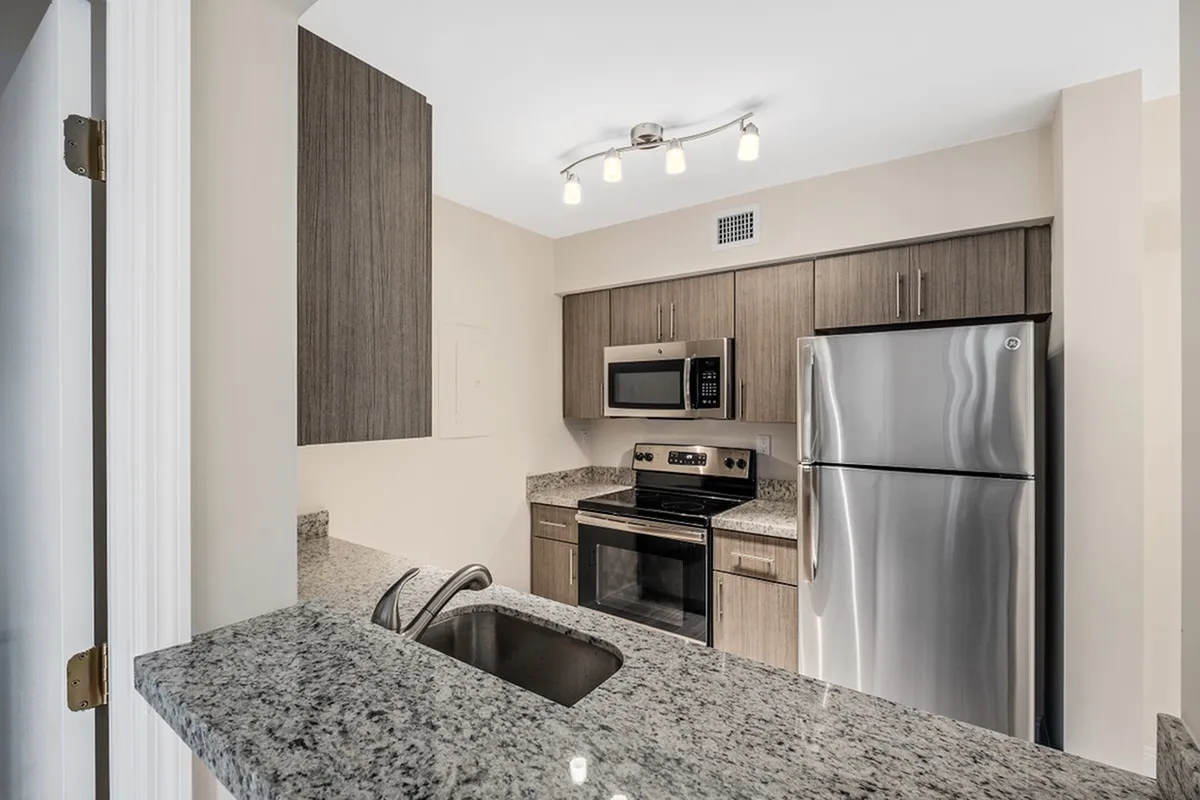 Modern apartment kitchen with stainless steel appliances and granite countertops
