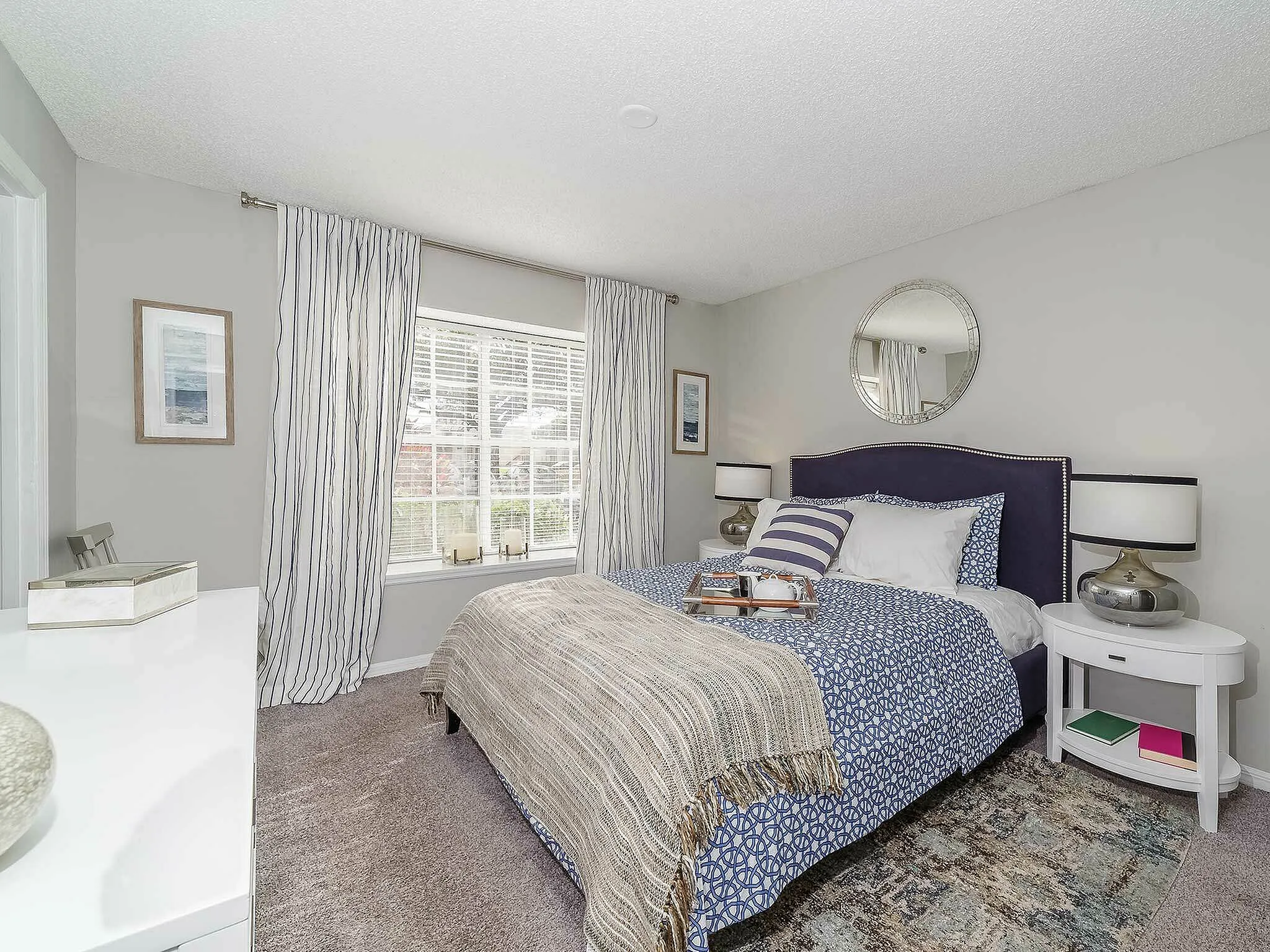 Bright and inviting bedroom with elegant decor, featuring a large window, plush bedding, and stylish furnishings.