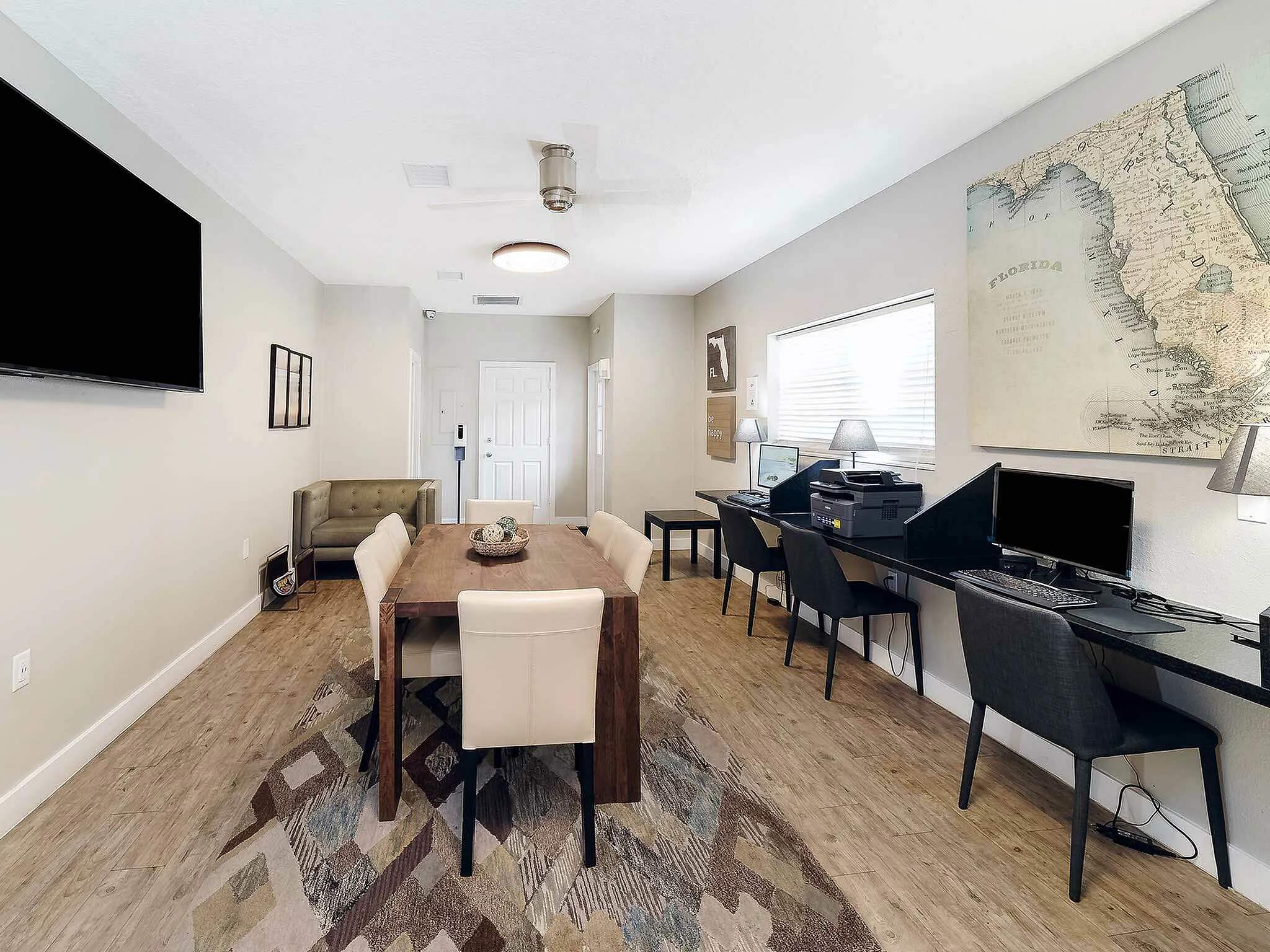Sleek and modern workspace with a stylish dining area, featuring wooden flooring, elegant furniture, and maps for decor.