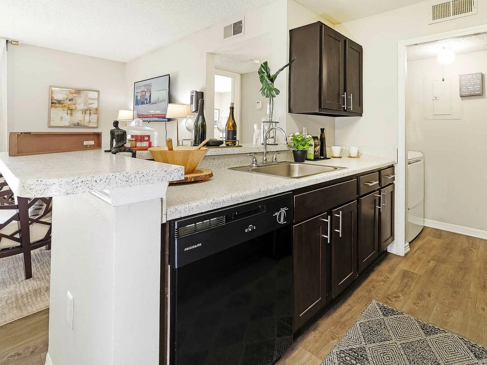 Modern kitchen with sleek dark cabinets, granite countertops, and integrated appliances.