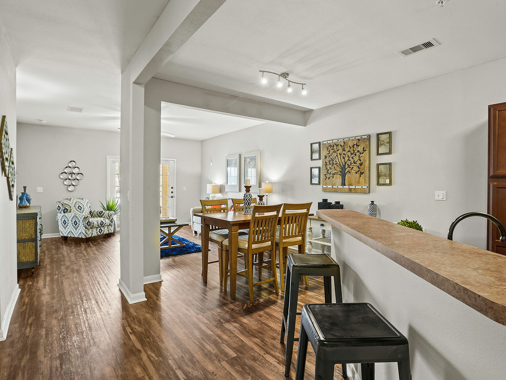 Modern open-concept living space with stylish decor, featuring dining area, cozy seating, and hardwood floors.