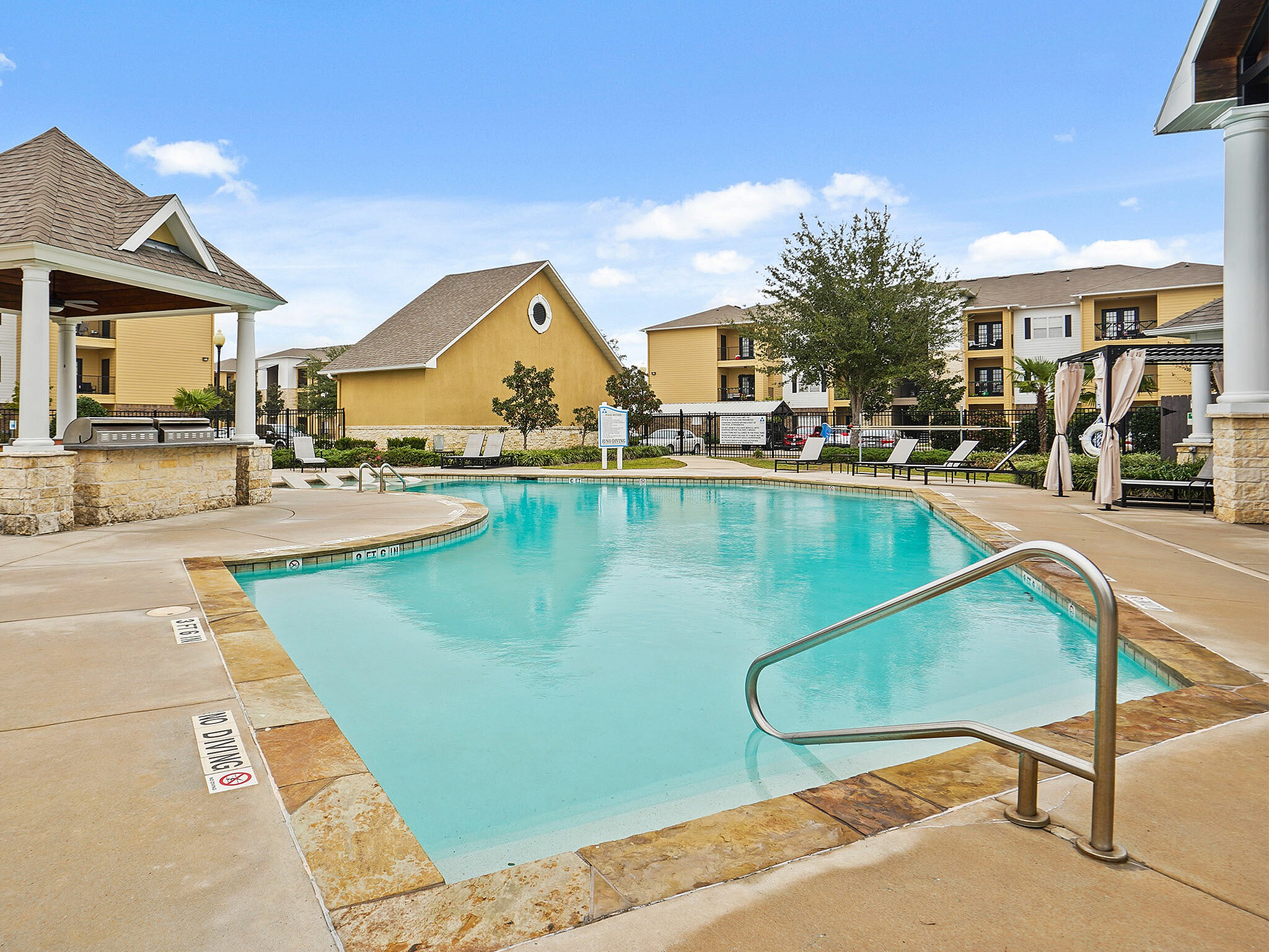 Inviting community pool surrounded by cozy homes and lush greenery.