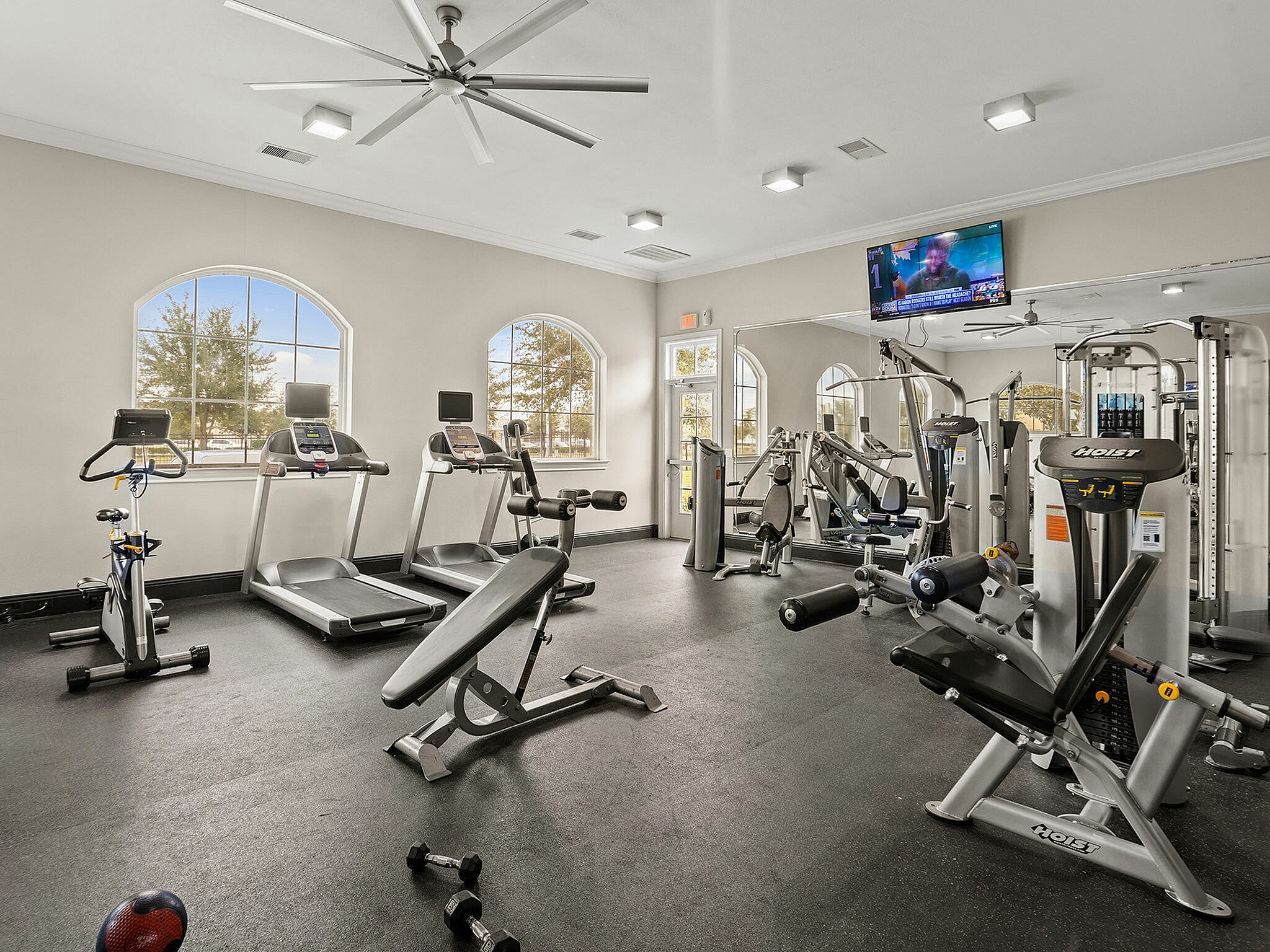 Spacious fitness center with modern equipment including treadmills and strength machines.