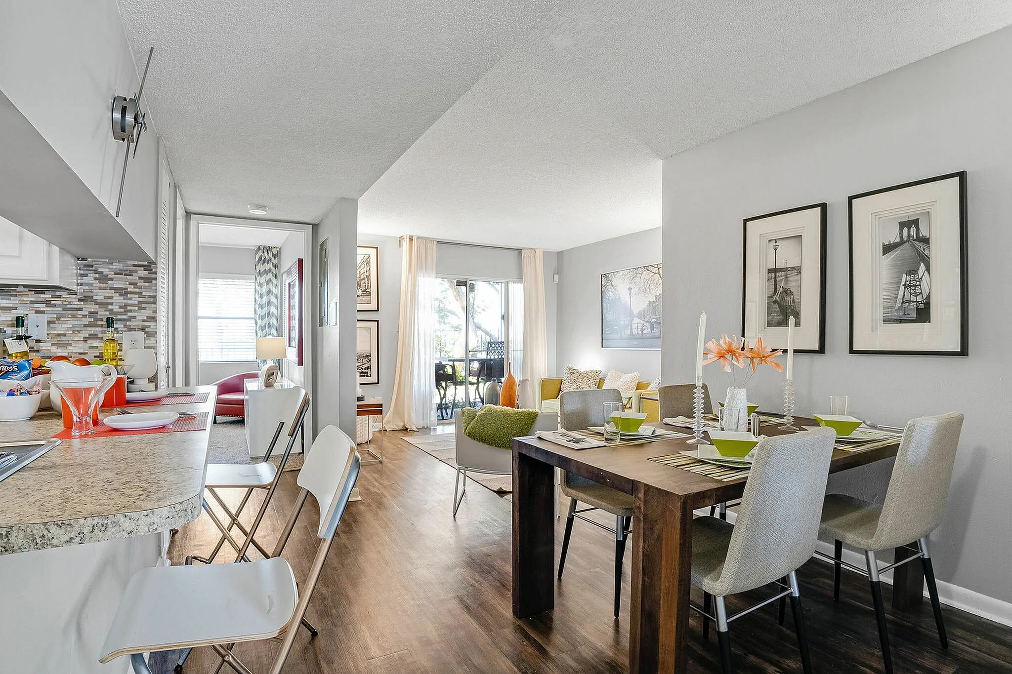 Bright modern apartment interior featuring a spacious open kitchen, cozy living area, and elegant dining setup with vibrant decor and natural light.