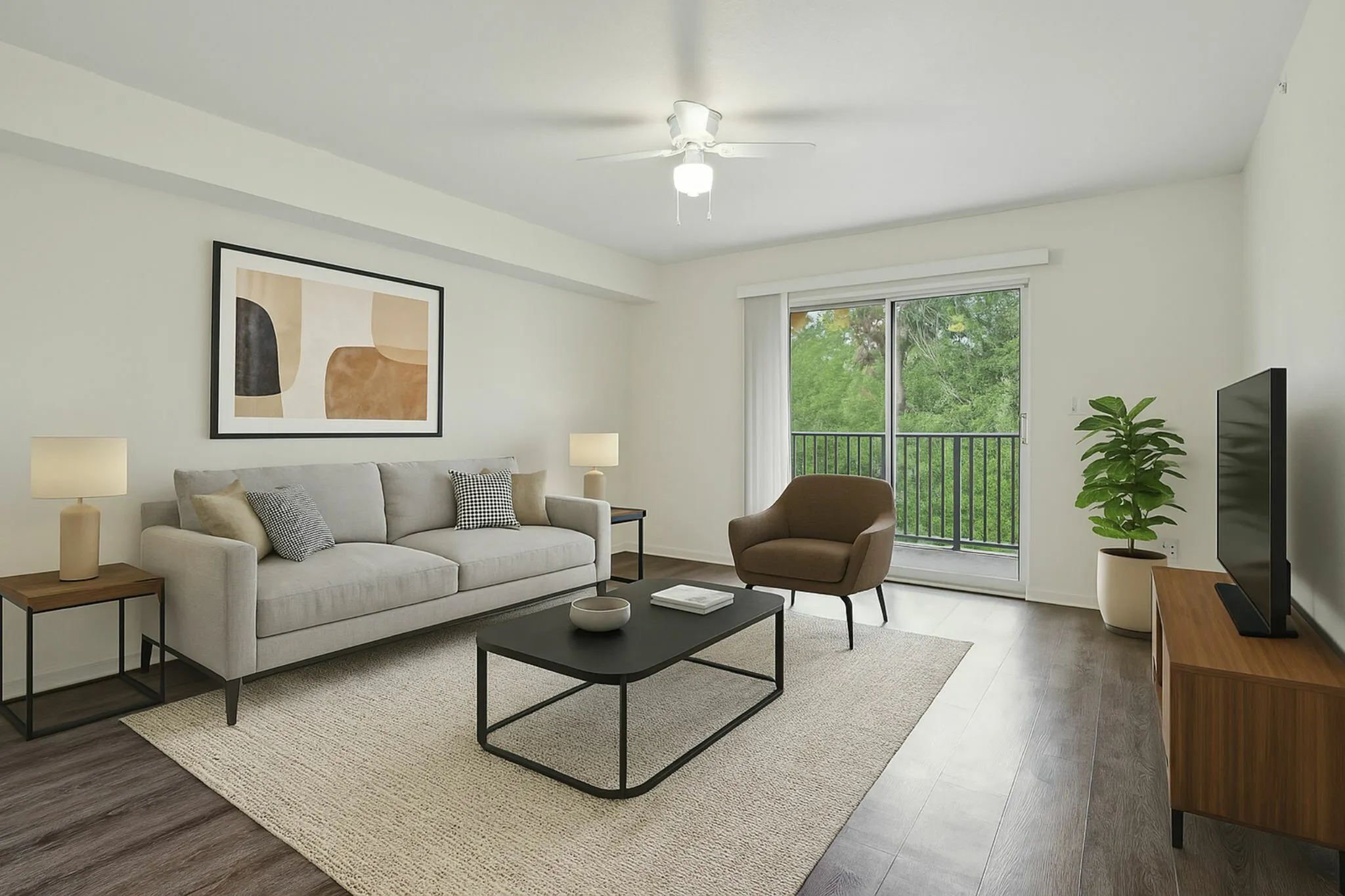 Chic living room with modern decor, cozy seating, large windows offering lush greenery views.