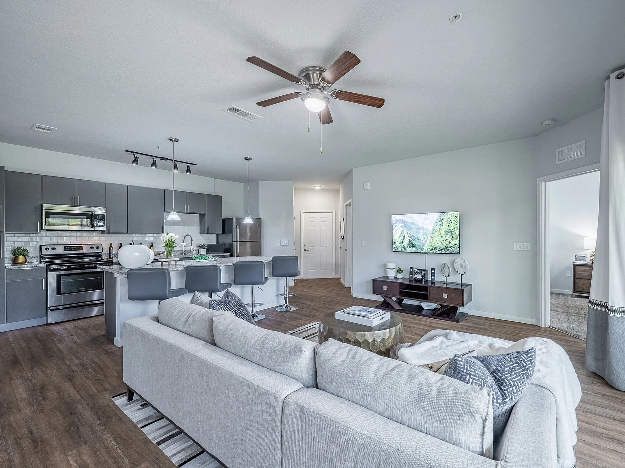 Modern open-plan apartment featuring a sleek kitchen, cozy living area, and elegant decor, ideal for contemporary living.