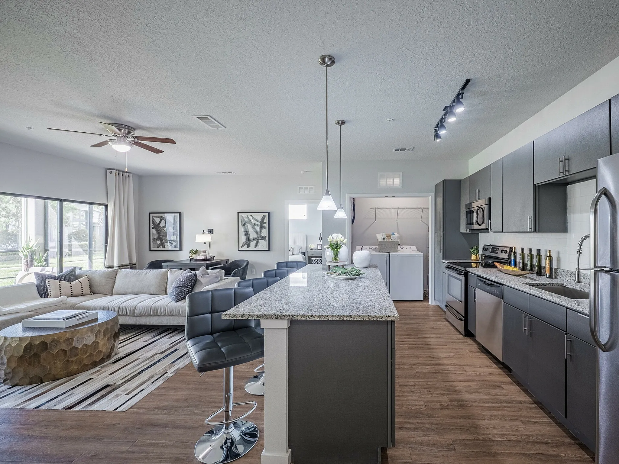 Modern open-concept apartment with sleek kitchen, spacious living room, stylish decor, and ample natural light.