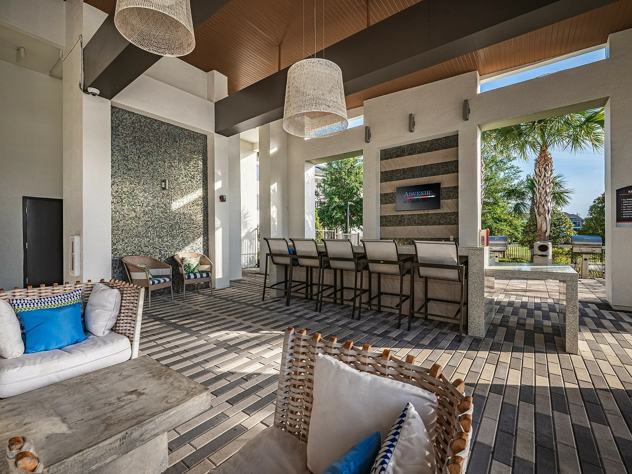 Chic outdoor lounge area with modern seating, stylish bar, and lush greenery, perfect for relaxation and entertaining.