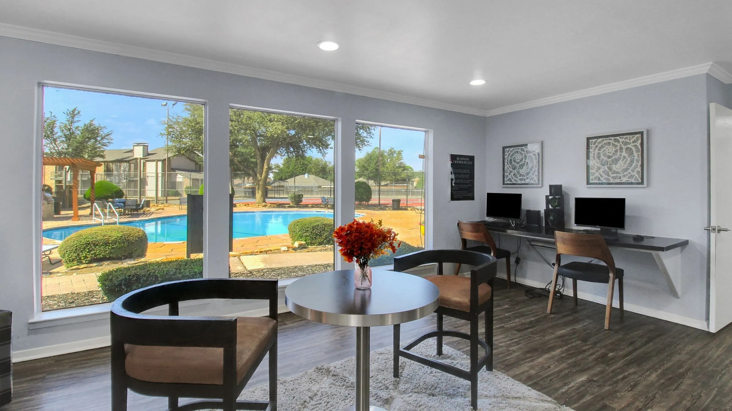 Bright and inviting workspace with modern decor and a stunning pool view, perfect for relaxation and productivity.