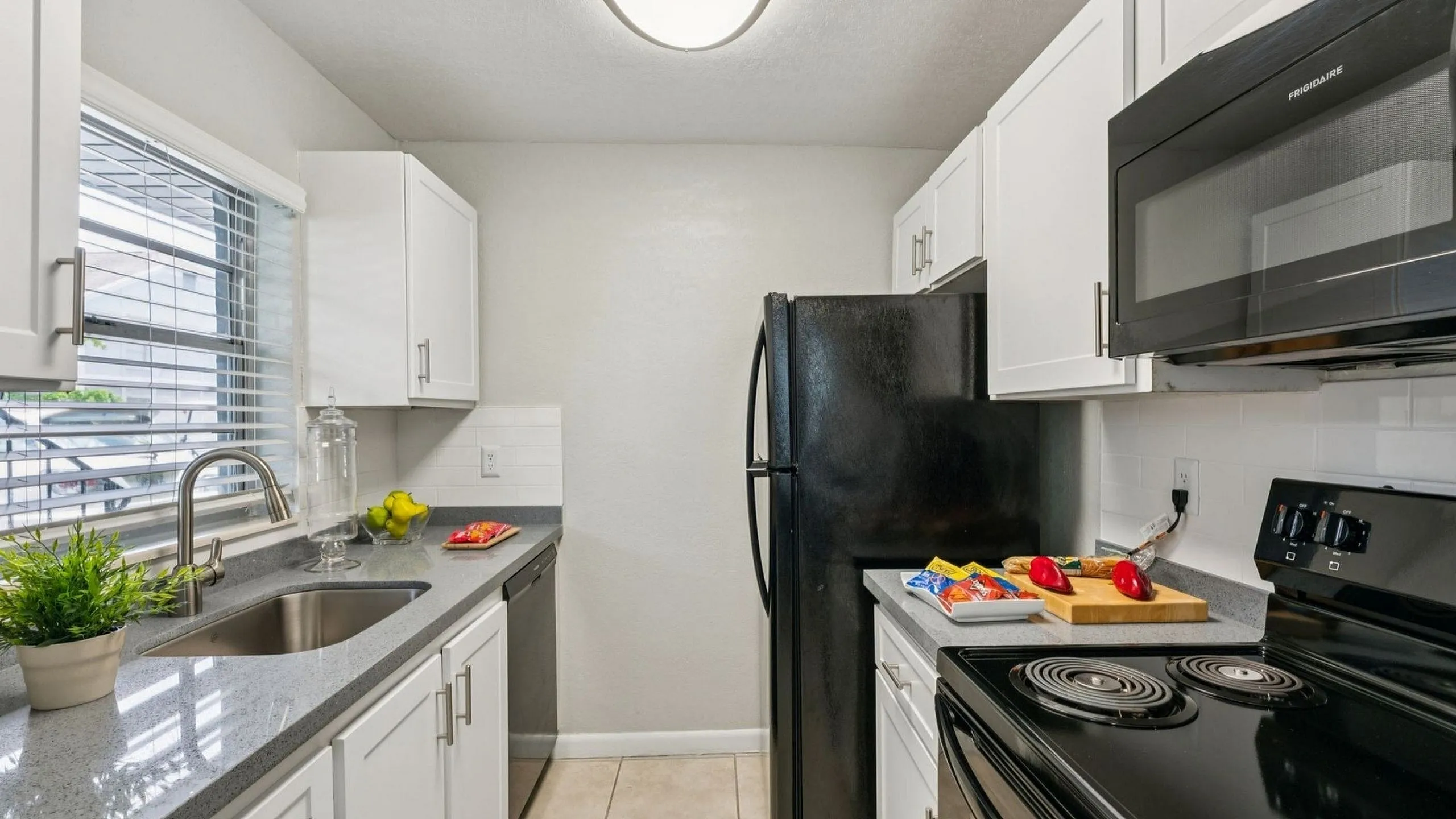 Modern kitchen with sleek white cabinetry, granite countertops, and stainless steel appliances, perfect for gourmet cooking.