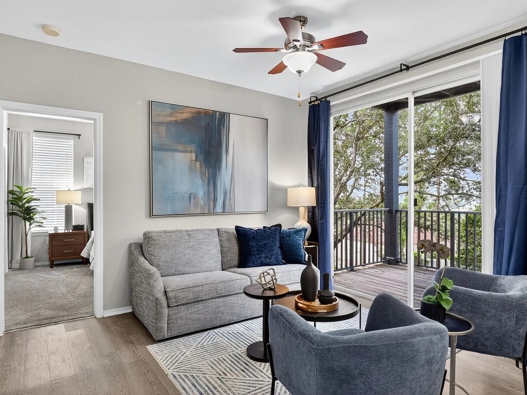 Sophisticated living room with elegant decor, cozy seating, and large windows opening to a scenic balcony.