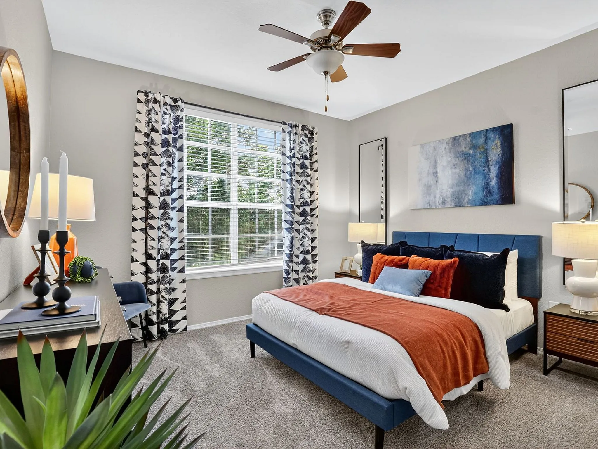 Chic bedroom with contemporary decor, featuring a plush bed with vibrant pillows, stylish curtains, and elegant lighting, all creating a cozy and inviting ambiance.