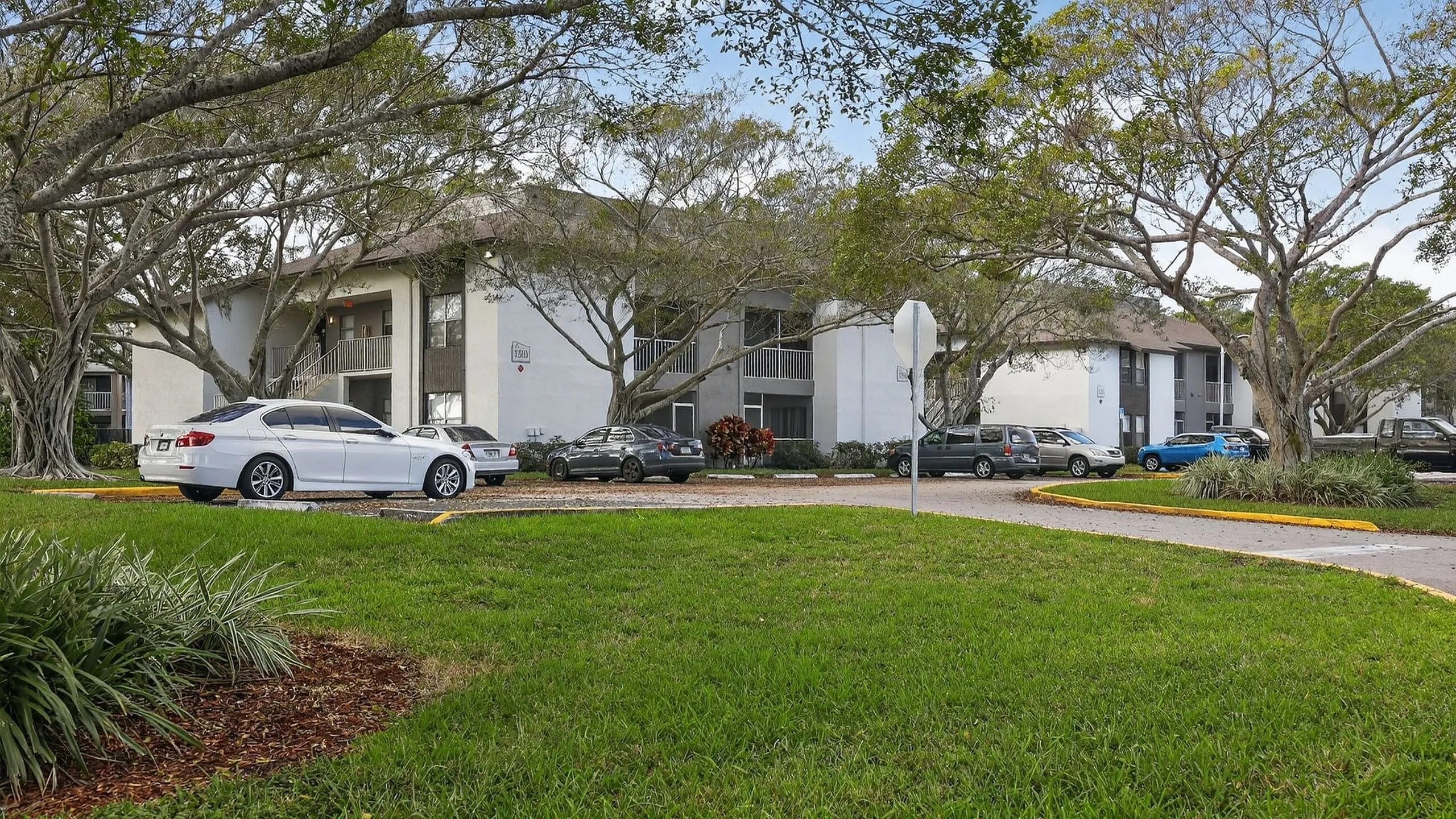Charming apartment complex surrounded by lush greenery and modern parking facilities, offering a serene living environment.