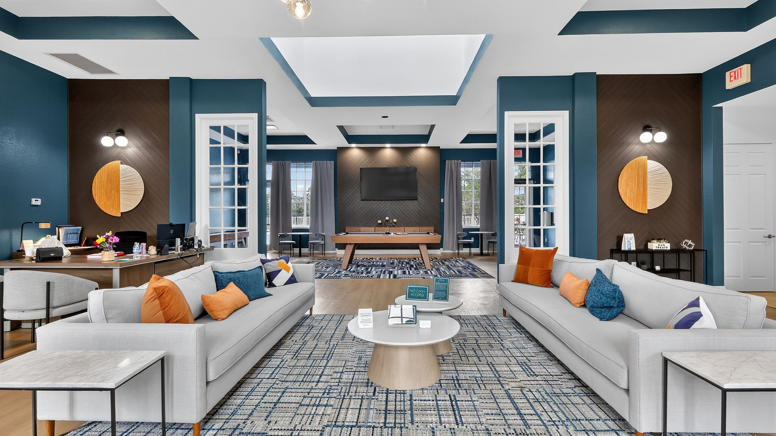 Modern, spacious lounge area with elegant blue and white decor, plush seating, and abundant natural light.