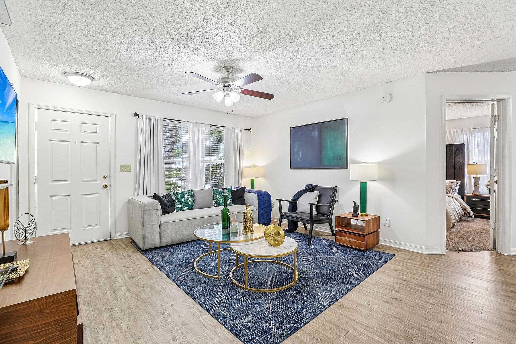 Bright and inviting living room with modern decor, stylish furniture, and cozy bedroom entrance.