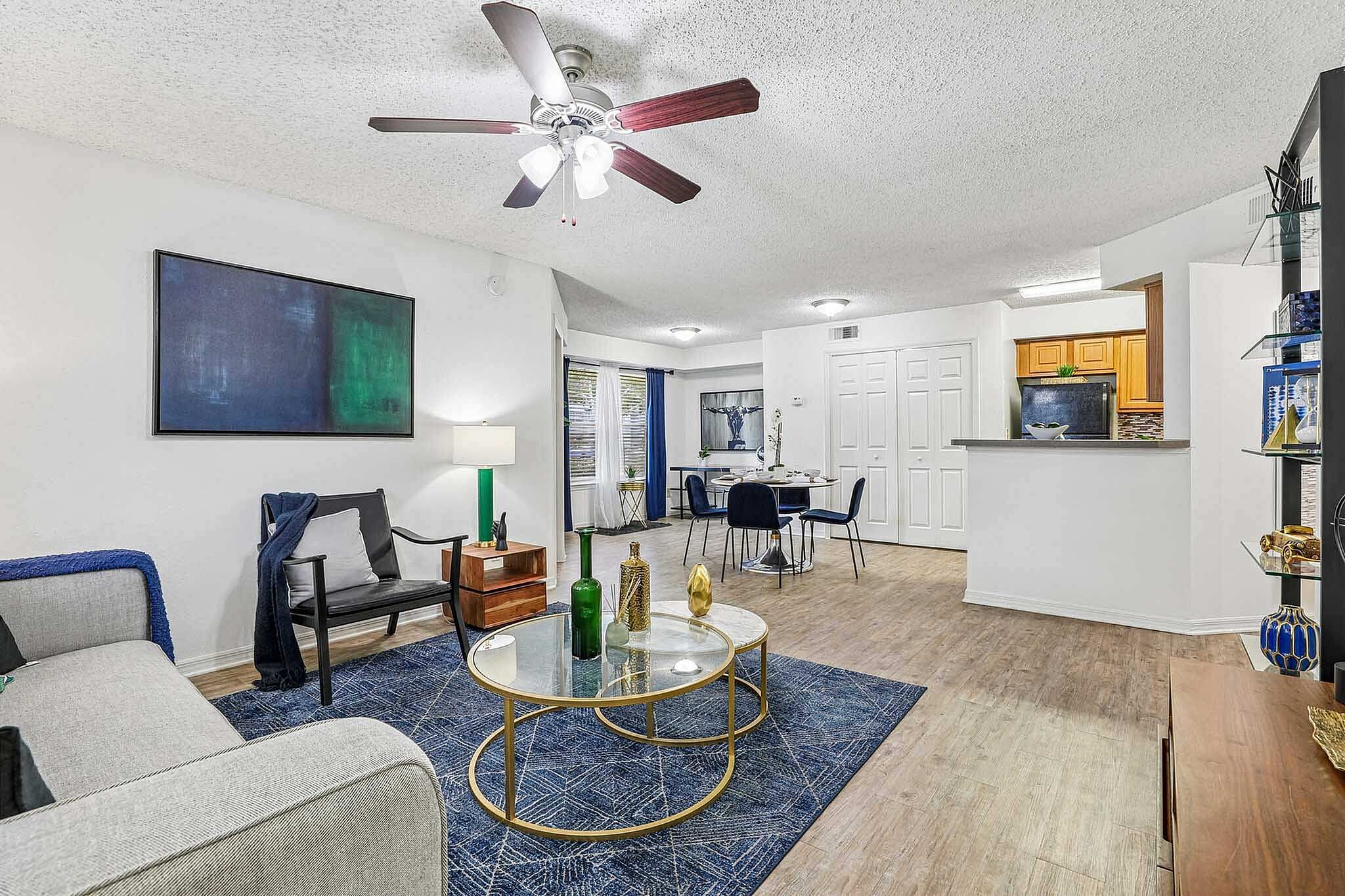 Modern open-concept living and dining area with stylish decor, featuring a cozy living room with elegant furniture, vibrant artwork, and a chic dining space with contemporary accents.