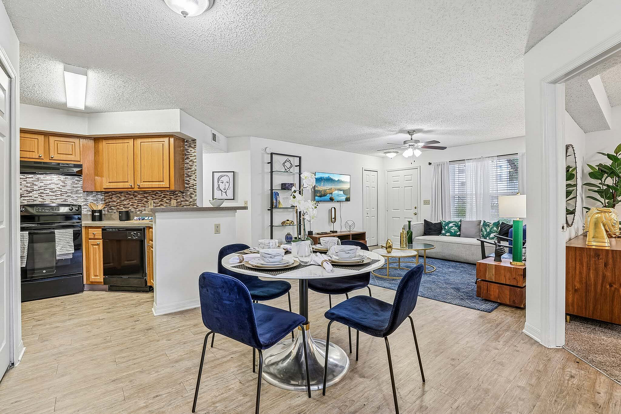 Inviting living space with a modern kitchen and cozy dining area. Featuring a stylish living room with elegant decor, plush seating, and warm wooden accents.
