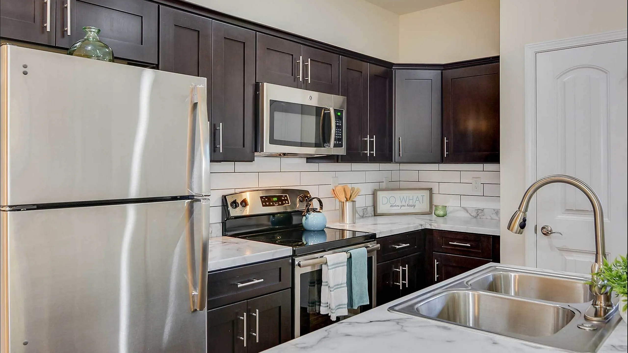 Contemporary kitchen with stainless steel appliances and dark cabinetry