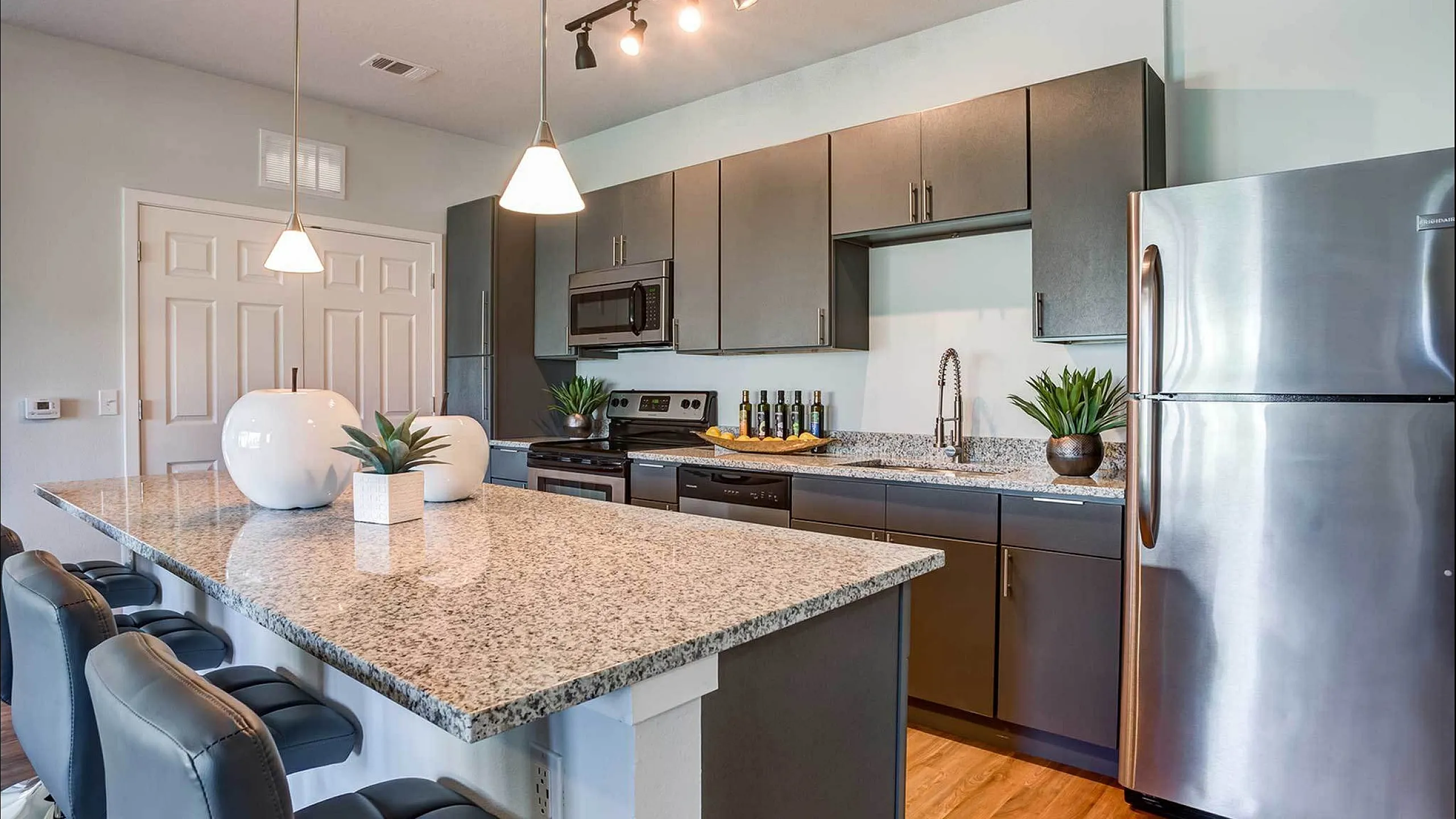 Stylish kitchen with granite countertops, modern appliances, and elegant lighting.