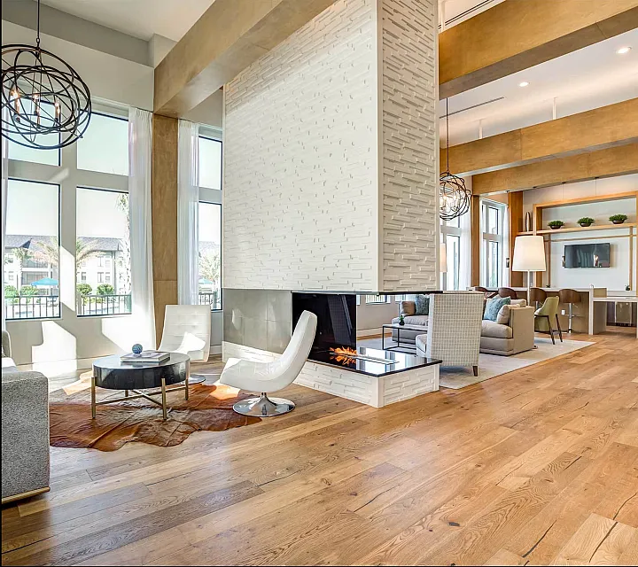 Spacious modern lounge with elegant decor, featuring a fireplace and large windows.