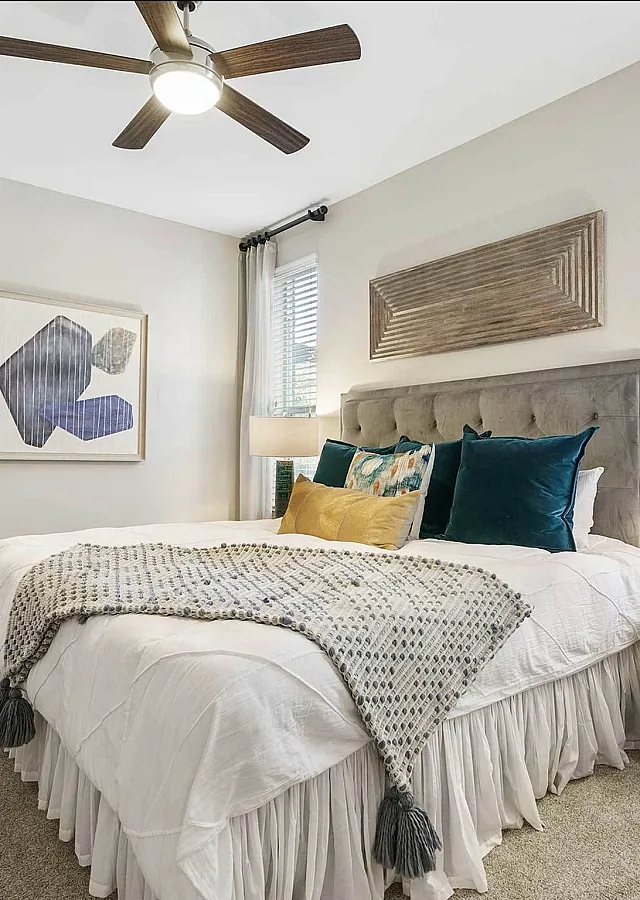 Modern bedroom with plush bed, stylish lamps, and natural light