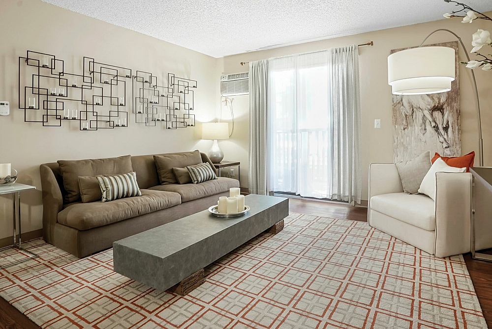 Modern living room with cozy brown sofa, abstract wall art, and large windows with natural light
