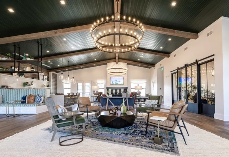 Luxurious open-plan lounge featuring chic seating, stylish decor, and a grand chandelier.