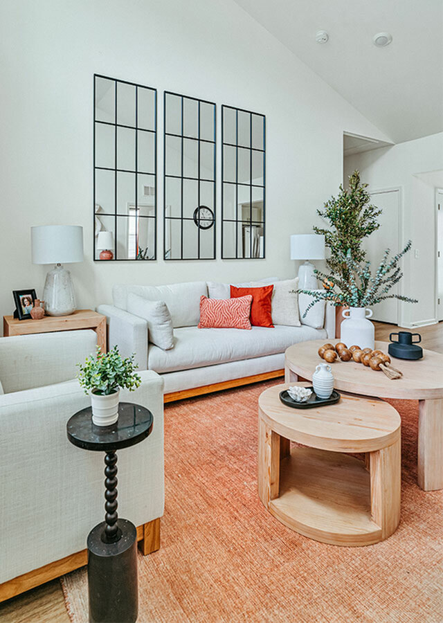 Inviting living room with cozy white sofas, vibrant orange accents, and chic decor elements creating a warm ambiance.