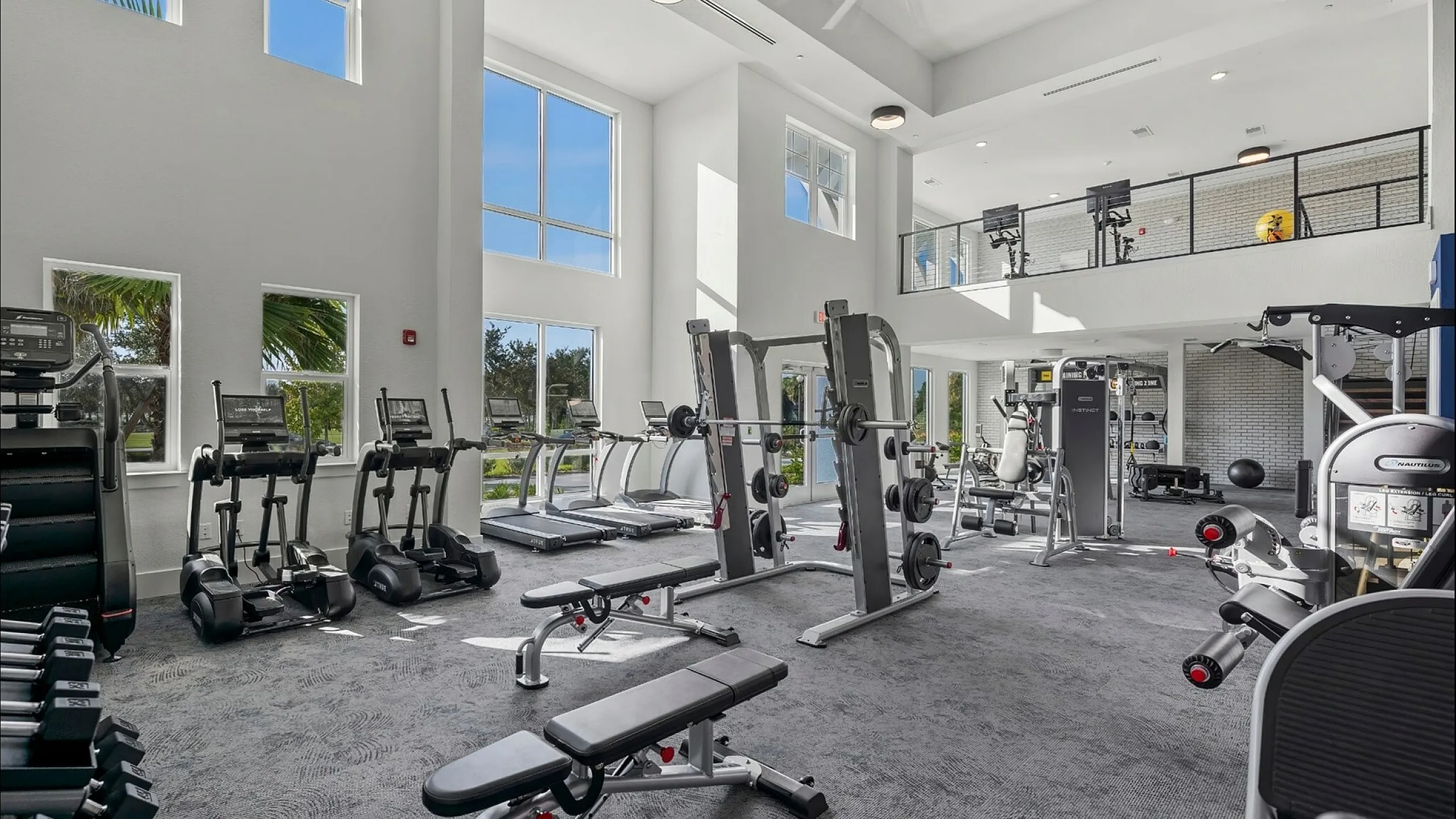 Bright, spacious gym with modern equipment and large windows offering scenic views, perfect for invigorating workouts.
