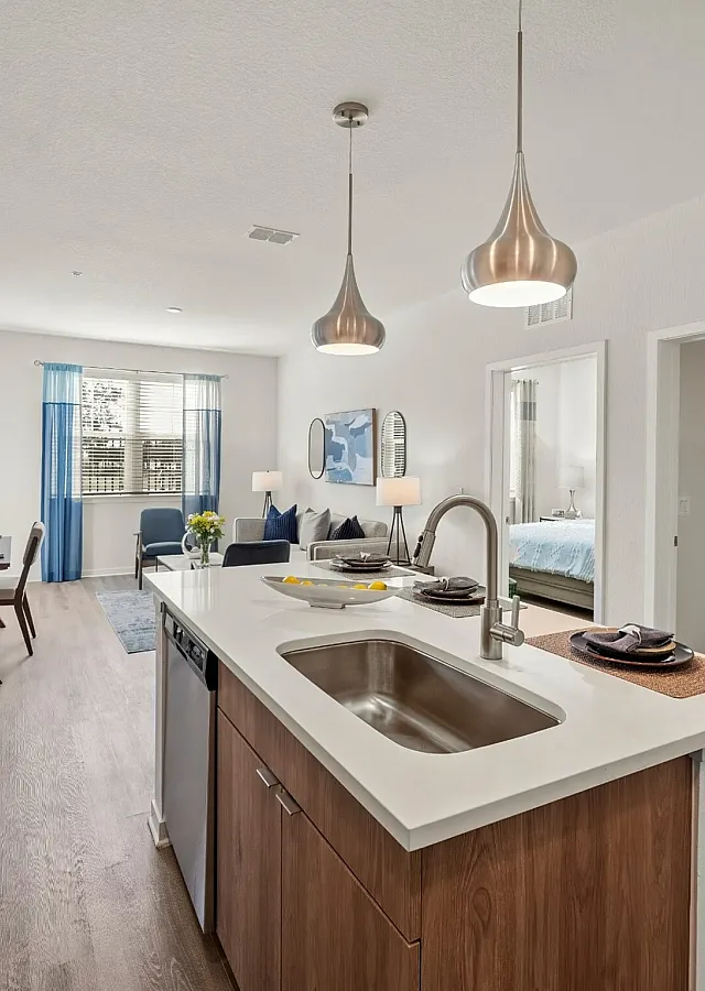 Chic apartment interior featuring modern kitchen island, elegant lighting, and open living space with stylish decor.