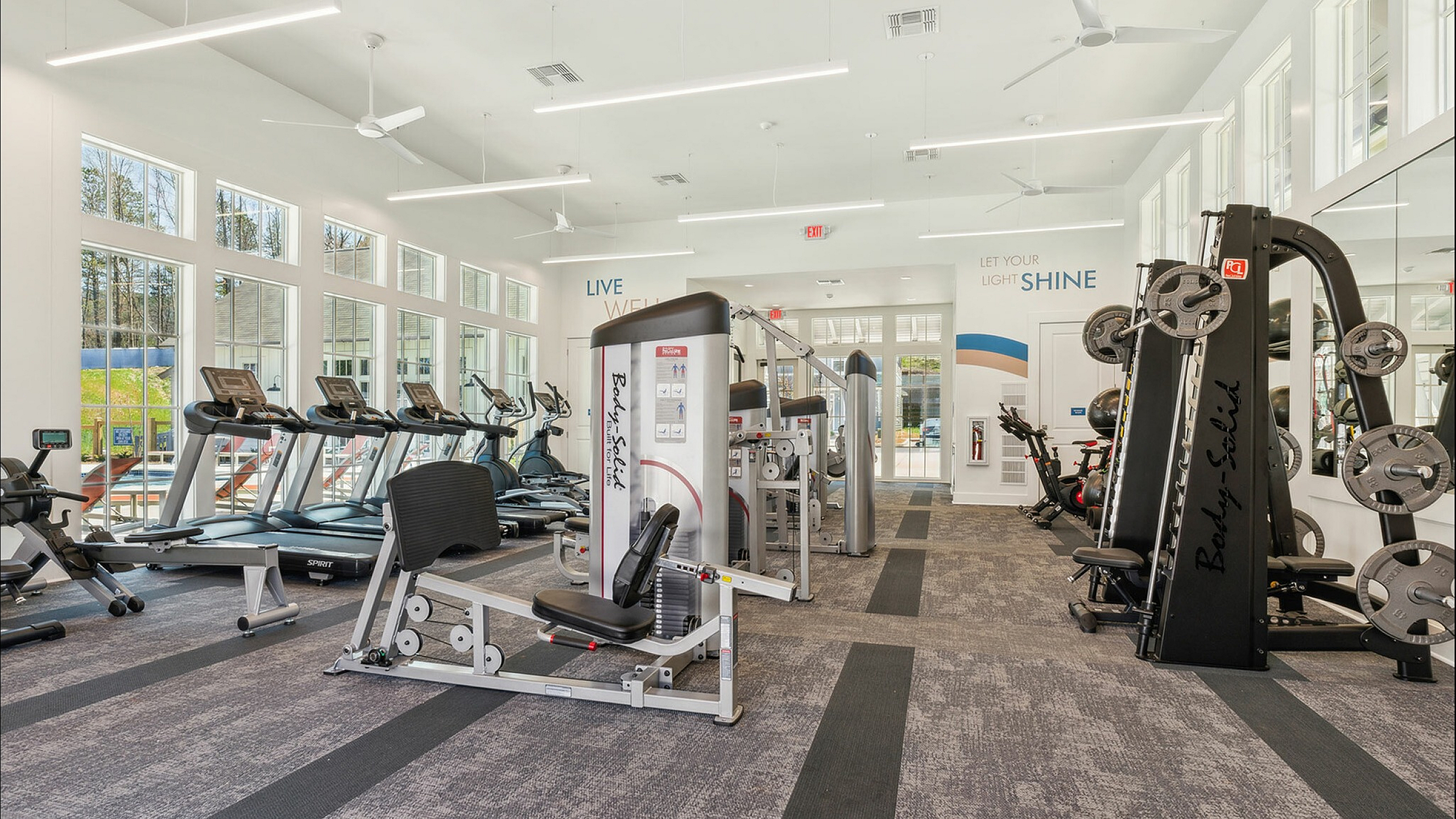 Bright, modern fitness center equipped with state-of-the-art machines and large windows for natural light.