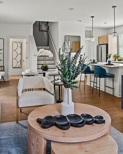 Inviting open-concept living area featuring elegant decor, modern kitchen with bar seating, and stylish furnishings, perfect for contemporary living.