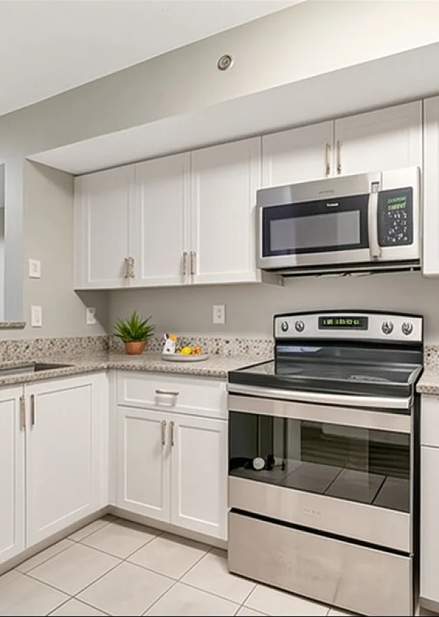 Modern kitchen with sleek stainless steel appliances, elegant granite countertops, and stylish white cabinetry.