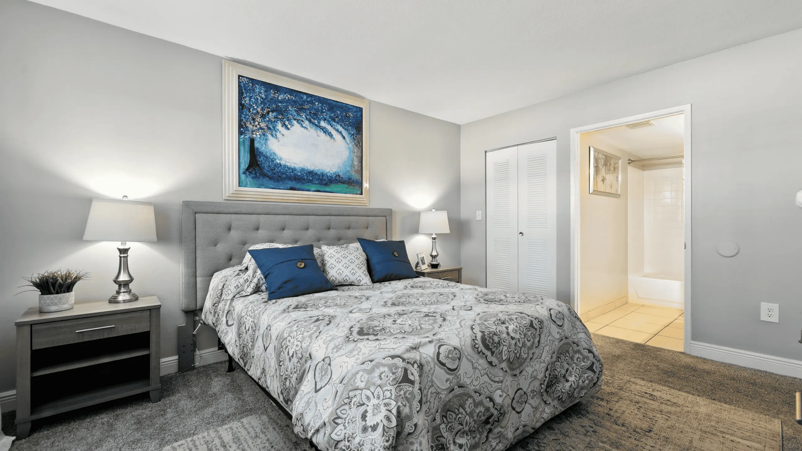 Elegant bedroom with luxurious bedding, modern decor, and attached bathroom.